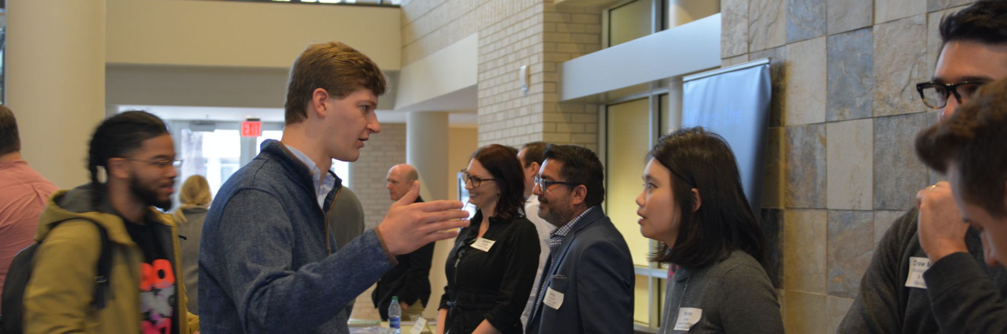 header image of students and potential employers at the externship expo