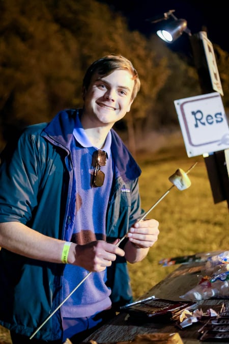 Law student roasts a marshmallow at a cookout